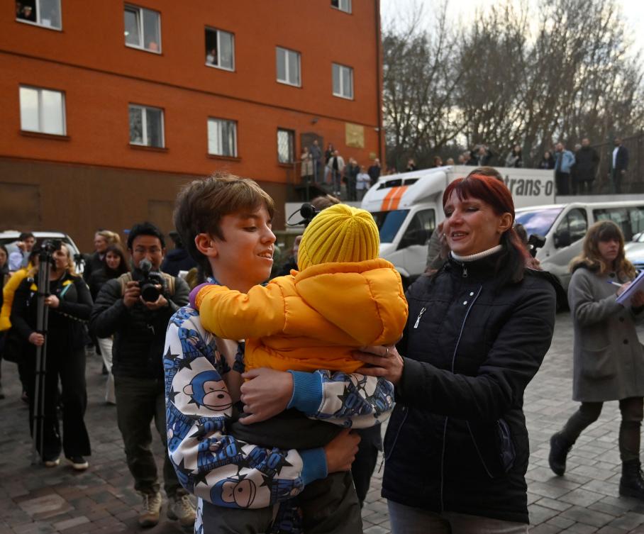 Inessa meets her son Vitaly after the bus delivering him and more than a dozen other children back from Russian-held territory arrived in Kyiv on March 22, 2023. (AFP)