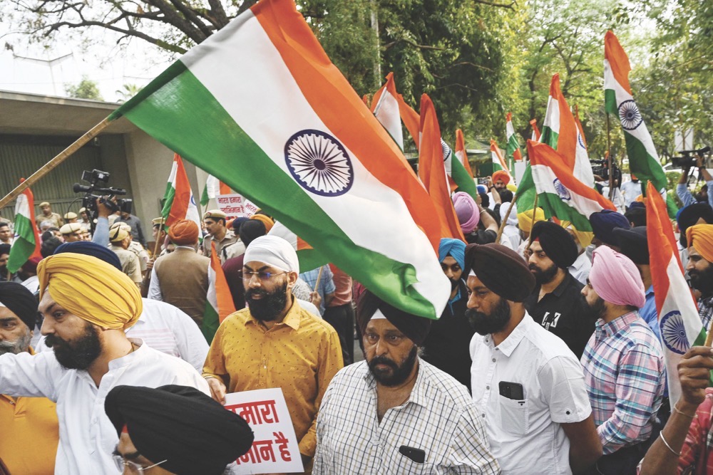 Sikh men hold Indian national flags during a protest in New Delhi against the supporters of radical Sikh preacher Amritpal Singh, on Monday. (AFP)