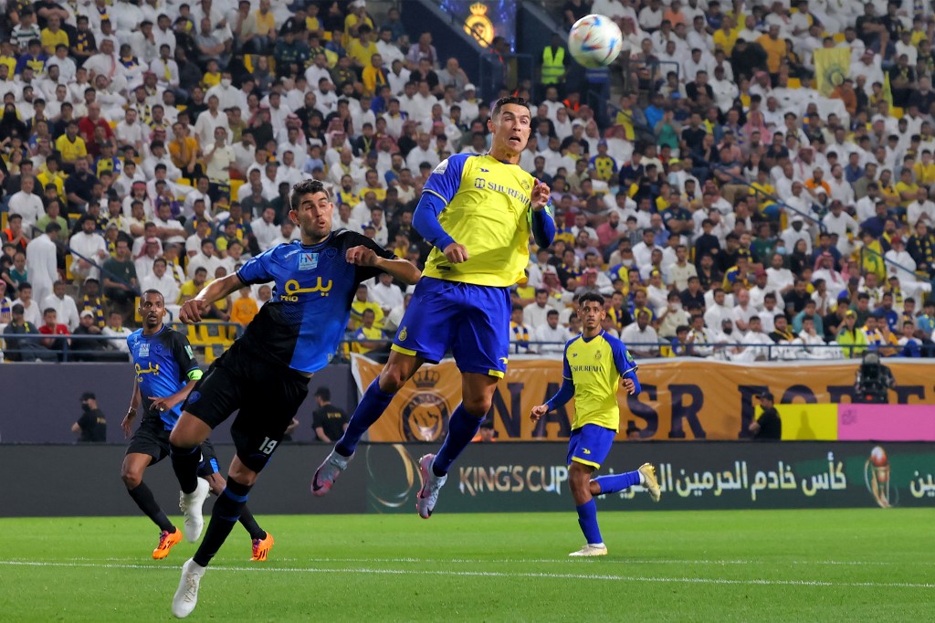 Abha’s Amine Atouchi vies for a header against Al-Nassr’s Cristiano Ronaldo during their teams’ King Cup quarterfinal match in Riyadh on March 14, 2023. (AFP)