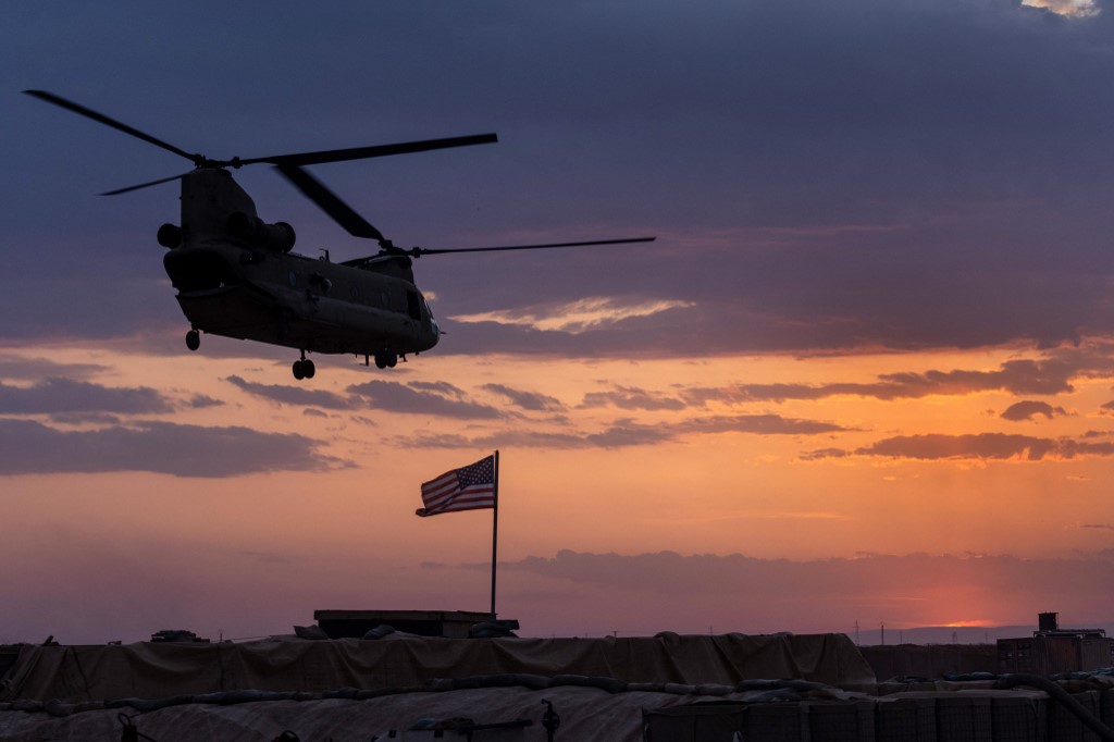 A U.S. Army CH-47 Chinook helicopter takes off at sunset while transporting American troops out of a remote combat outpost in northeastern Syria.(AFP)