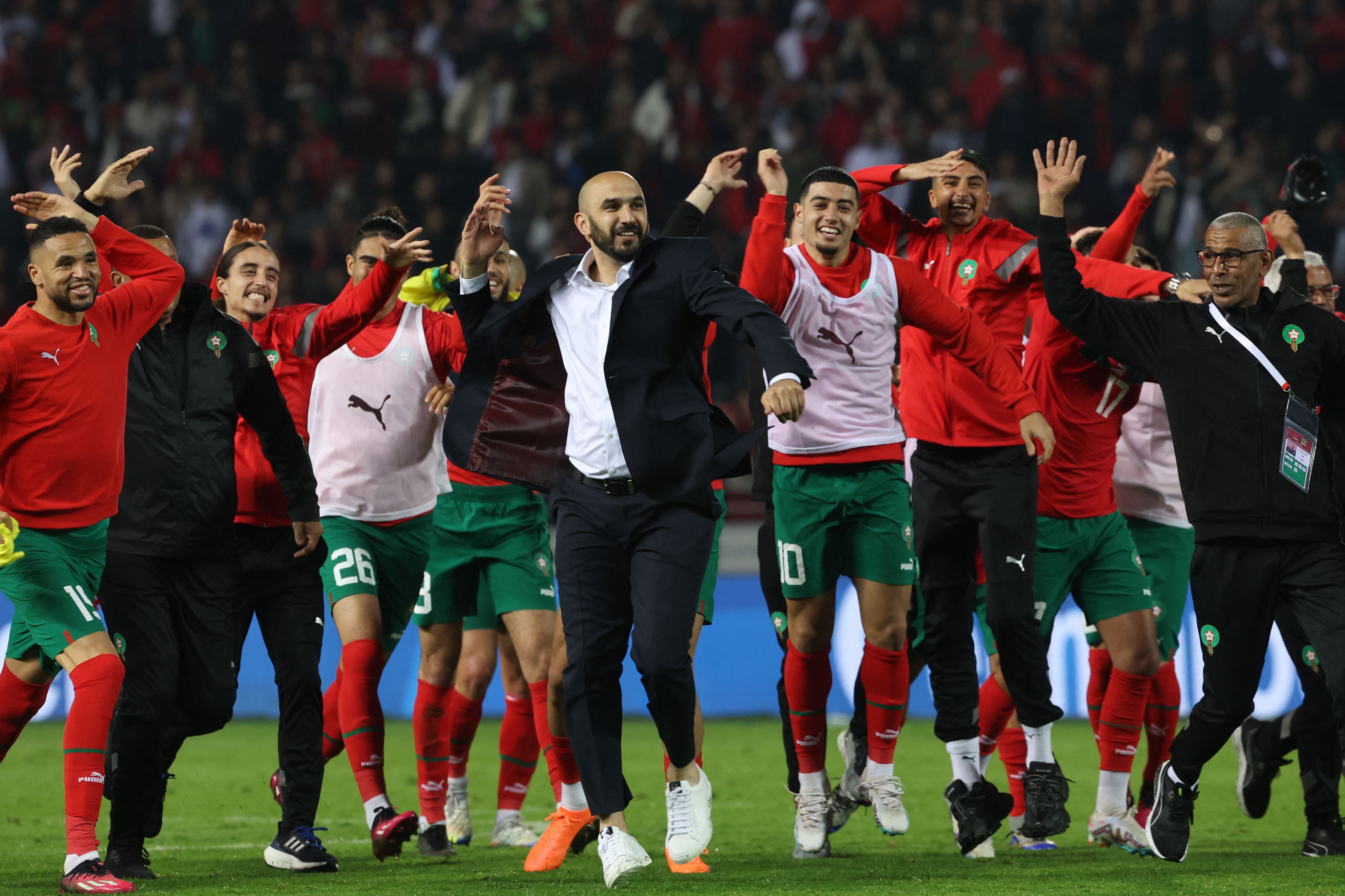 Morocco's coach Walid Regragui (C) and his players greet the fans after the friendly football match between Morocco and Brazil at the Ibn Batouta Stadium in Tangier where Morocco won 2-1. (AFP)