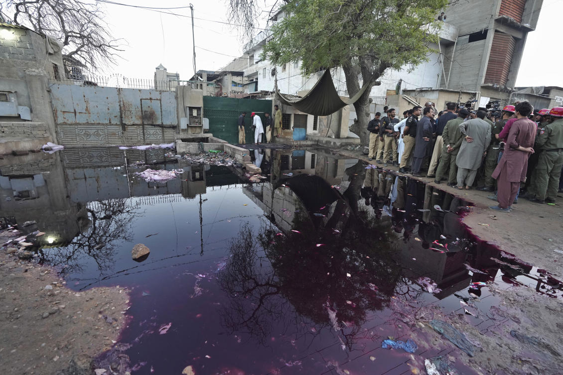 Police officers and members of media gather at the site of stampede, in Karachi, Pakistan on Mar. 31, 2023. (AP)