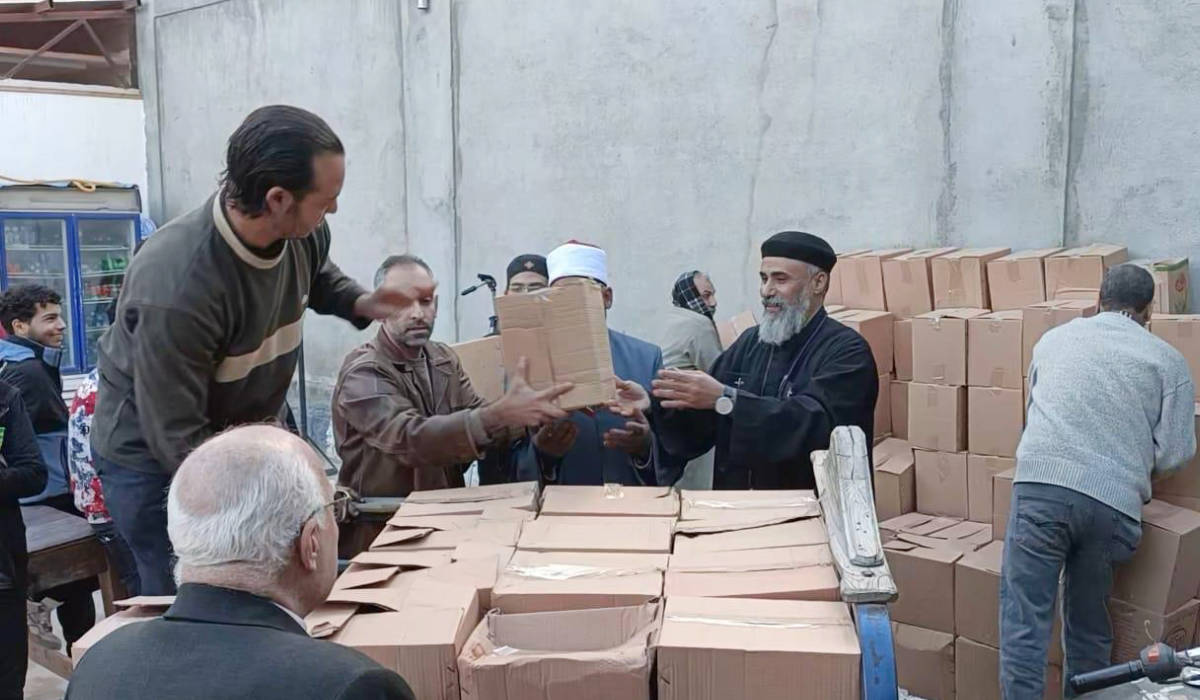 Archpriest Raphael Helmy, priest of the Church of the Virgin Mary, Pope Kyrollos in Alexandria, and Sheikh Saad Khalif, the imam and preacher of the Al-Aziz Al-Rahim Mosque, adjacent to the church, during the preparation of Ramadan boxes. (Supplied)
