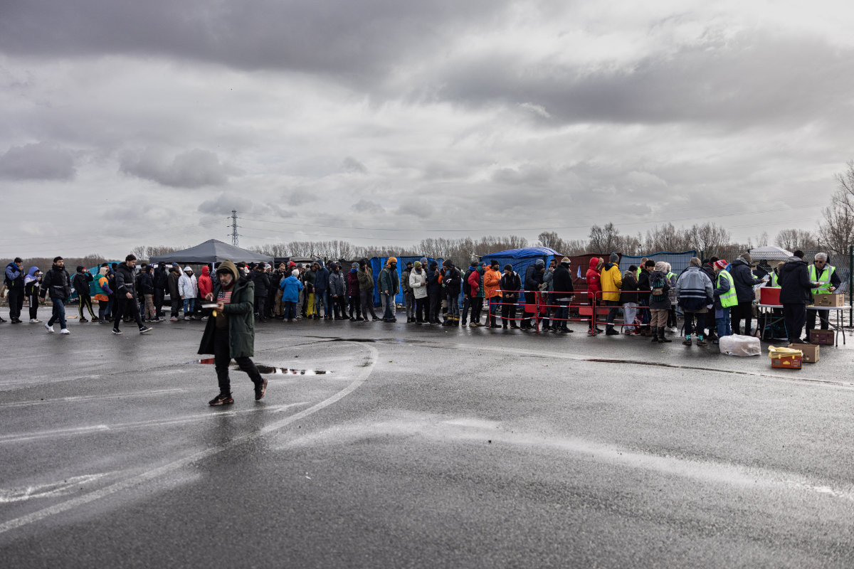 Migrants line up for food in Mardyck, northern France, where they have set up camp as they attempt to enter Britain. (AFP)