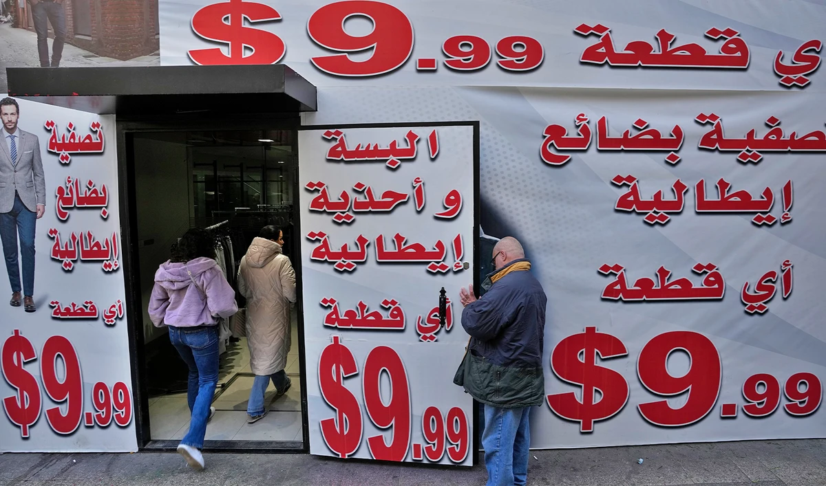 Store displays advertising in Arabic that reads "Italian clothes and shoes for 9.99 $" in Beirut, Lebanon, on March 1, 2023. (AP)