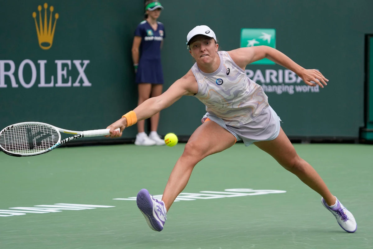 Iga Swiatek returns a shot to Claire Liu at the BNP Paribas Open tennis tournament on March 11, 2023, in Indian Wells, California (AP)
