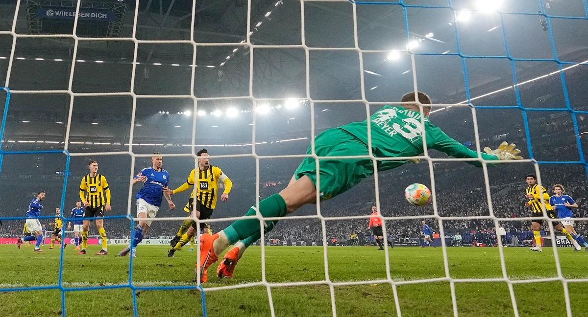Schalke's Kenan Karaman, left, scores his side's second goal past Dortmund's goalkeeper Alexander Meyer, right, during their German Bundesliga soccer match in Gelsenkirchen, Germany, Saturday. (AP)