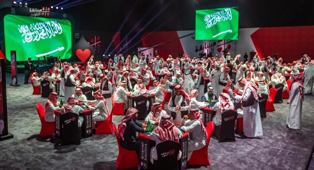 Hammad Al-Enezi and Hammam Al-Harbi raise a symbolic check after their victory in the Baloot competition. (Supplied)