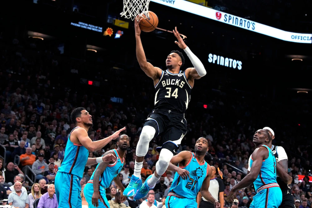 Milwaukee Bucks forward Giannis Antetokounmpo drives between Phoenix Suns guard Devin Booker, left, guard Terrence Ross (8), forward T.J. Warren (21) and center Bismack Biyombo, right, during the first half of an NBA game Tuesday in Phoenix. (AP)