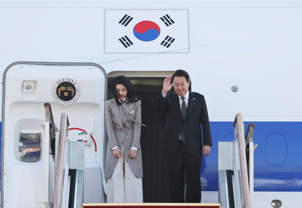 South Korean President Yoon Suk Yeol waves as his wife Kim Keon Hee bows before departing for Japan at the Seoul military airport in Seongnam, South Korea, on March 16, 2023. (Yonhap via AP)