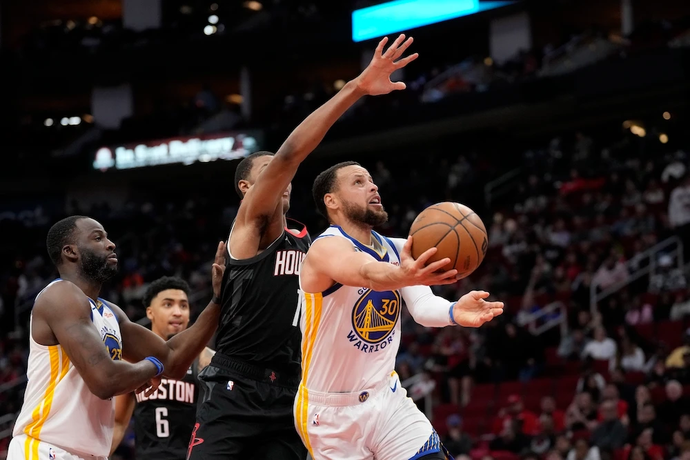 Golden State Warriors' Stephen Curry (30) shoots as Houston Rockets' Jabari Smith Jr. (1) defends during the second half of an NBA game Monday in Houston. The Warriors won 121-108. (AP)