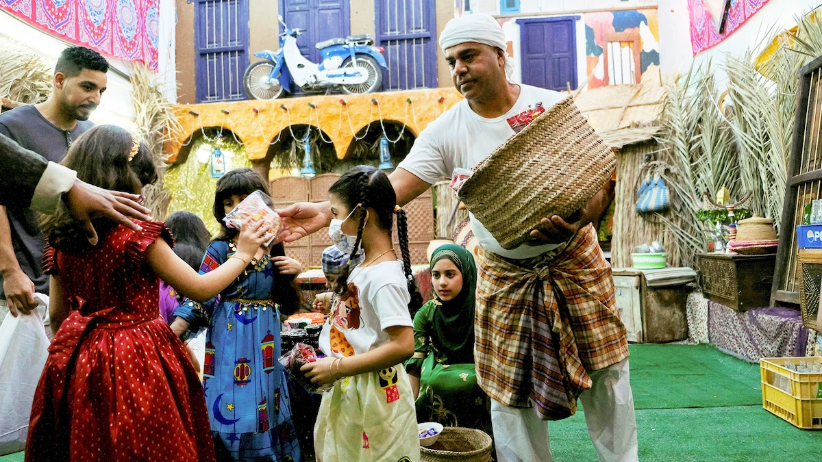 A Saudi man gives gifts to children as they celebrate Gargee’an during Ramadan. (Visit Saudi)