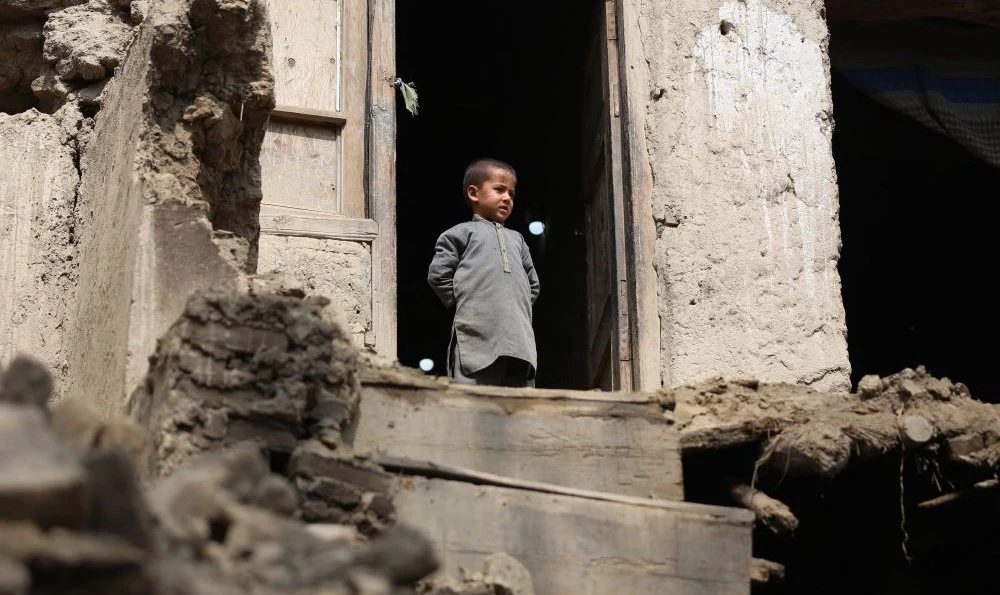 A boy looks out from his damaged home in Miya village, in the Alishing District of Laghman Province, Afghanistan, on March 22, 2023, following an overnight earthquake. (AFP)