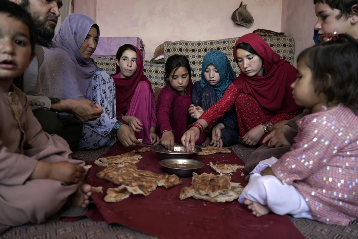 A family eats at their home in one of the poor neighborhoods of Kabul, Afghanistan, May 21, 2022. (AP Photo/File)