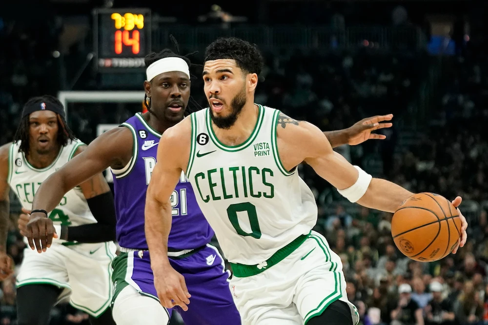 Boston Celtics’ Jayson Tatum drives to the basket against Milwaukee Bucks’ Jrue Holiday during the first half of an NBA game Thursday in Milwaukee. (AP)
