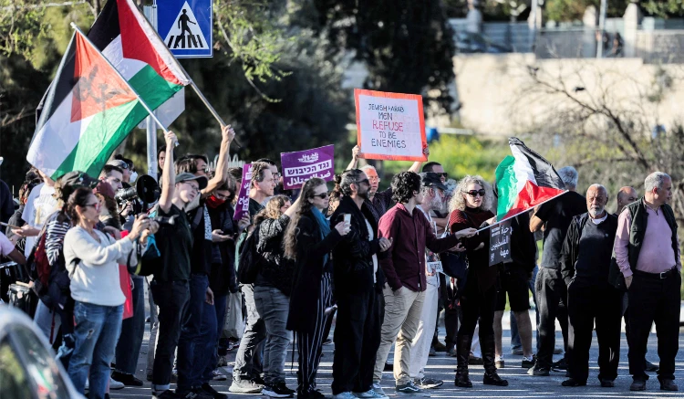 Israeli peace activists gather with Palestinian national flags during a demonstration against the eviction of Palestinians homes
