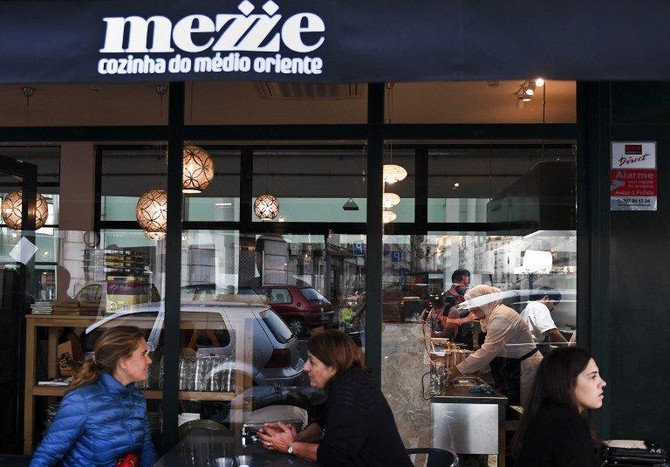 Clients sit outside the Syrian refugees-owned restaurant ‘Mezze’ in Lisbon on September 19, 2017. (AFP/File)