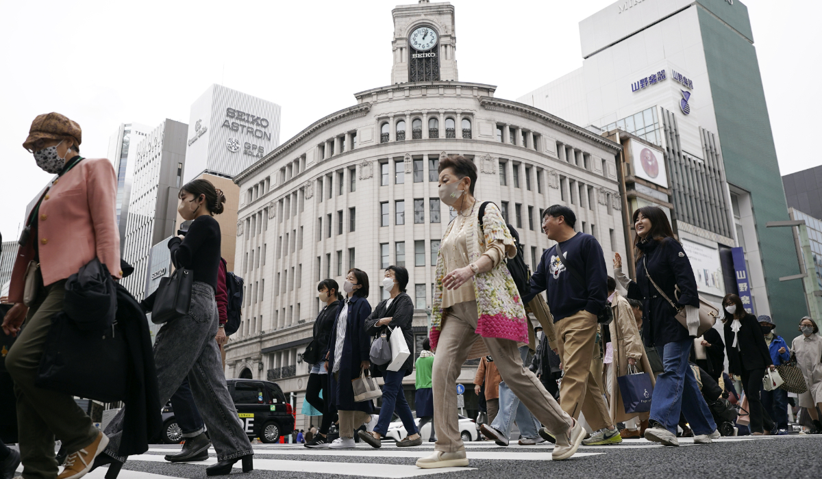 People walk at a pedestrian crossing in Ginza shopping district Friday, March 31, 2023, in Tokyo. (AP)