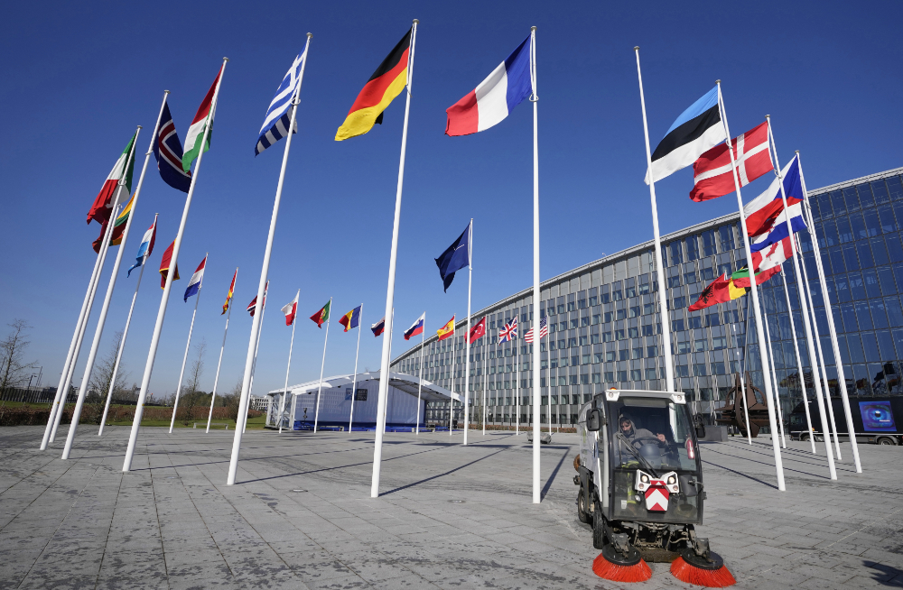 An empty flagpole stands between the national flags of France and Estonia outside NATO headquarters in Brussels, Monday, April 3, 2023. (AP)
