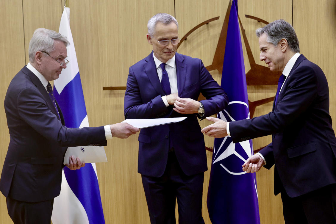 Finnish Foreign Minister Pekka Haavisto, left, hands his nation's accession document to United States Secretary of State Antony Blinken, right, during a meeting of NATO foreign ministers at NATO headquarters in Brussels, Tuesday, April 4, 2023. (AP)