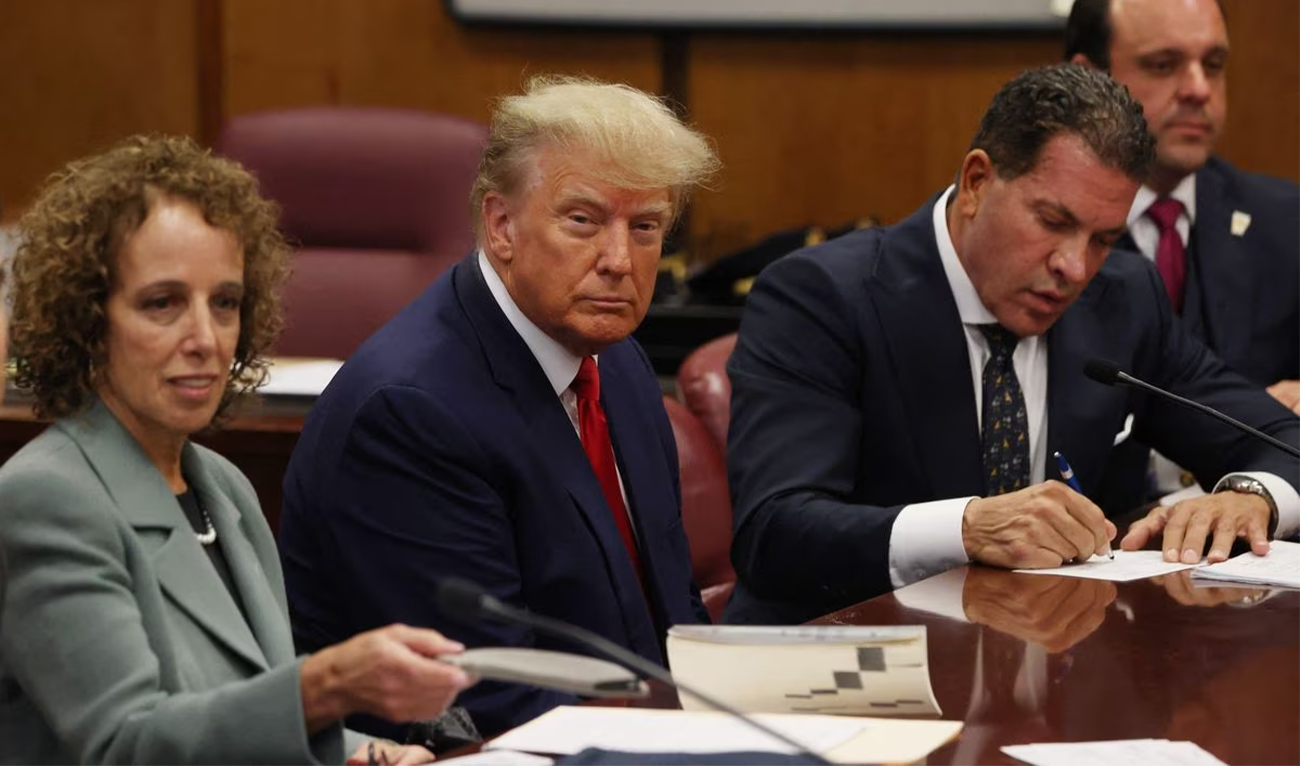Former U.S. President Donald Trump is accompanied by members of his legal team, Susan Necheles and Joe Tacopina, as he appears in court for an arraignment on charges stemming from his indictment by a Manhattan grand jury, on April 4, 2023. (REUTERS)