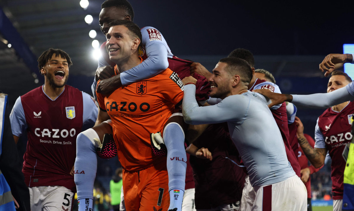 Aston Villa's Burkinese midfielder Bertrand Traore (2L) jumps on the back of Aston Villa's Argentinian goalkeeper Emiliano Martinez (C) as Aston Villa's players celebrate on the pitch after the Premier League against Leicester City on Tuesday. (AFP)