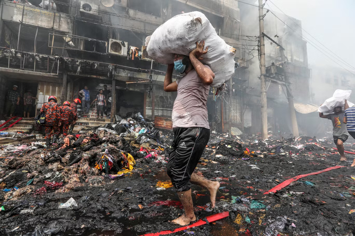 Shopkeepers salvage their goods from nearby shops as a fire rages at a popular cut-price clothing market in Dhaka, Bangladesh. (File/AP)