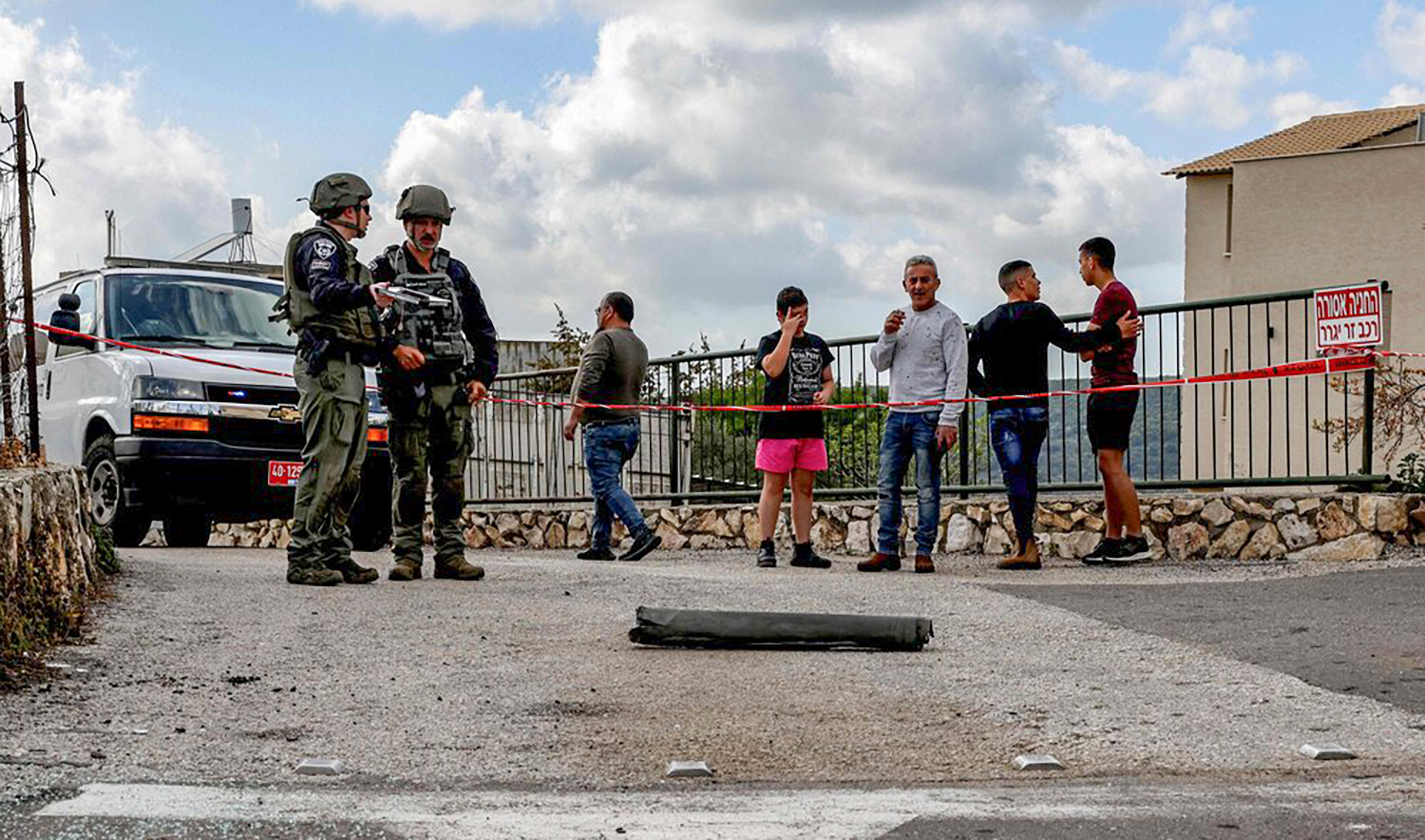 Israeli police bomb disposal unit members and other stand by the remains of a shell fired from Lebanon and intercepted by Israel in its northern town of Fassuta on Apr. 6, 2023. (AFP)