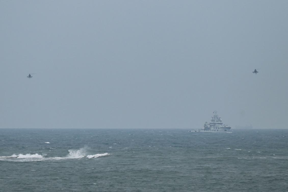 Two Chinese military helicopters fly past a PLA Navy tugboat, as seen from Pingtan island, the closest point to Taiwan, in China’s southeast Fujian province on April 7, 2023. (AFP)