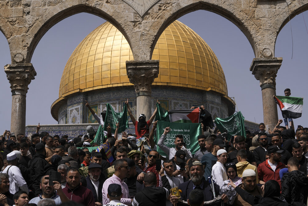 Palestinians hold the Palestinian national flag and the flag of the Hamas militant group during a protest by the Dome of Rock at the Al-Aqsa Mosque compound in the Old City of Jerusalem during the Muslim holy month of Ramadan, Apr. 7, 2023. (AP)