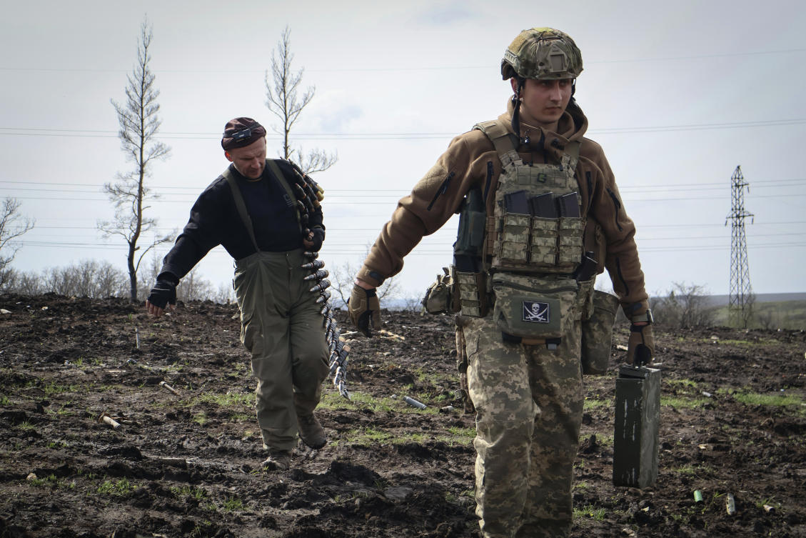 Ukrainian soldiers carry cartridges in their position on the frontline, near Bakhmut, Donetsk region, Ukraine, Friday, April 7, 2023. (Roman Chop via AP)