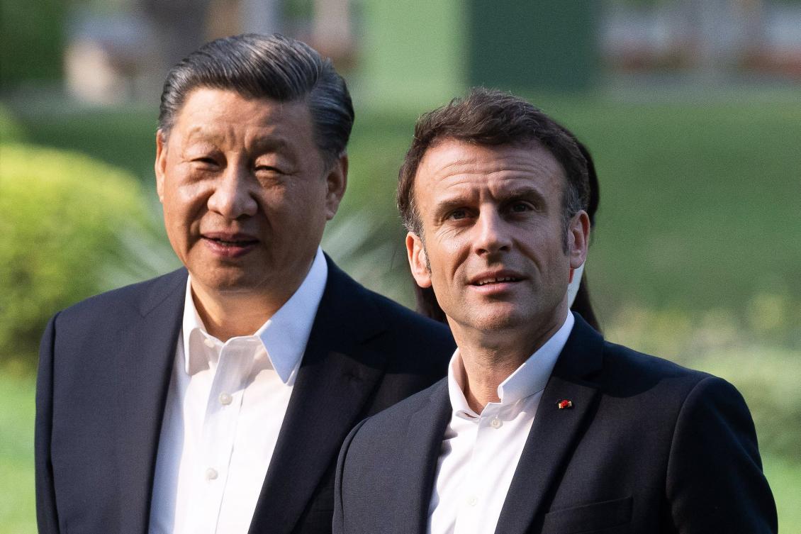 Chinese President Xi Jinping (L) and French President Emmanuel Macron (R) visit the garden of the residence of the Governor of Guangdong, on Friday. (AFP)