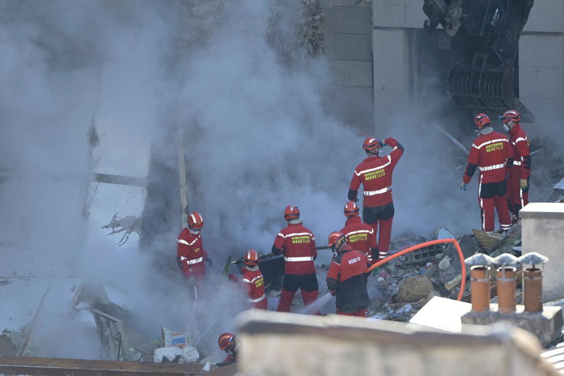 Firefighters work on the rubble at 'rue Tivoli' after a building collapsed in the street, in Marseille, southern France. (AFP)