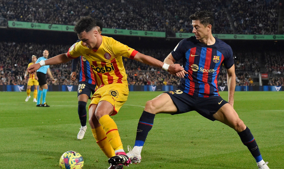 Girona's Spanish defender Arnau Martinez (L) vies with Barcelona's Polish forward Robert Lewandowski during the Spanish league football match between FC Barcelona and Girona FC at the Camp Nou stadium in Barcelona on April 10, 2023. (AFP)