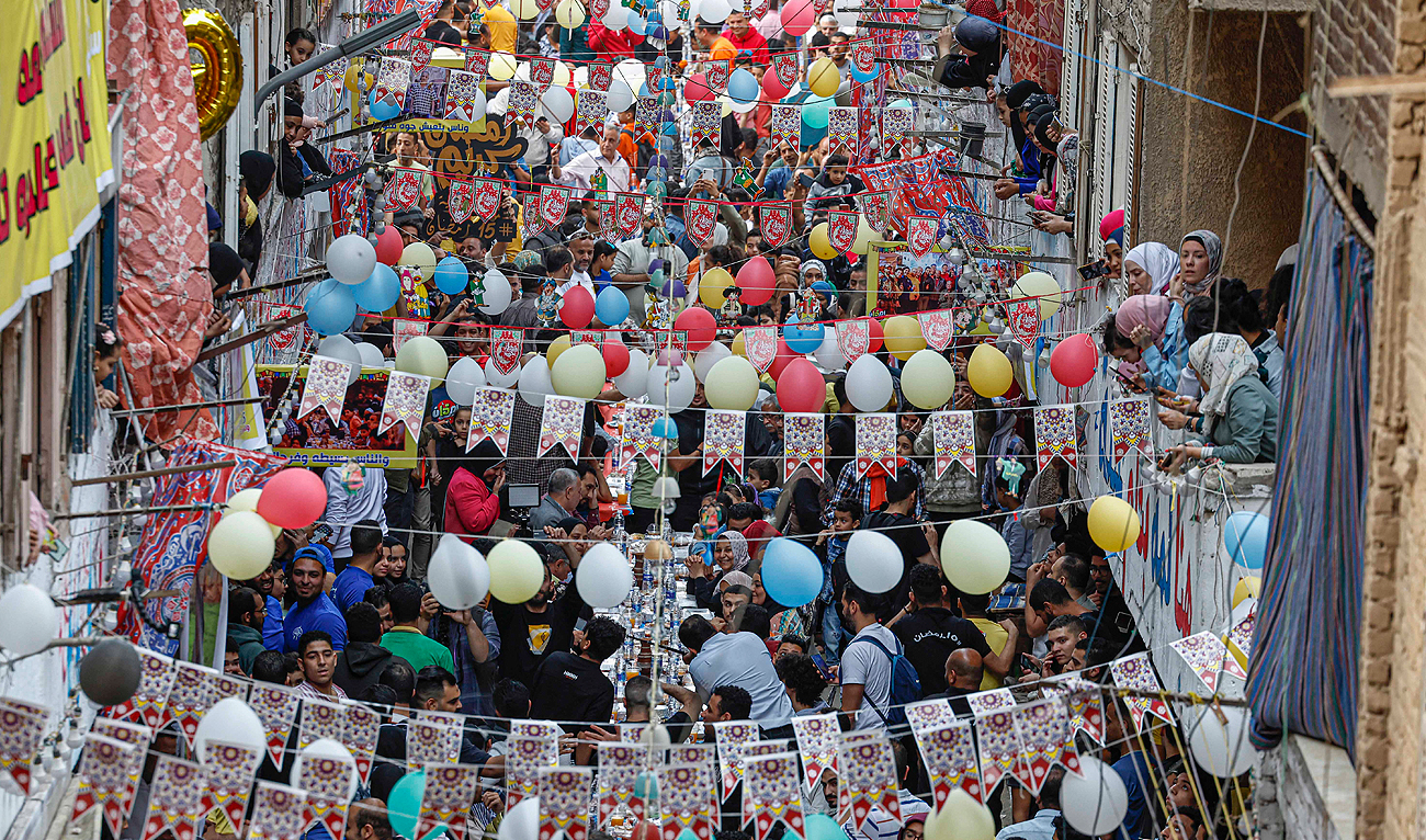 Egyptian Muslims gather in streets lined with long tables to break their Ramadan fast together in a mass "iftar" meal in Ezbet Hamada in Cairo's Matariya suburb in the northeast of Egypt's capital Cairo on April 6, 2023 on the 15th day of the Muslim holy month. (Photo courtesy: AFP)