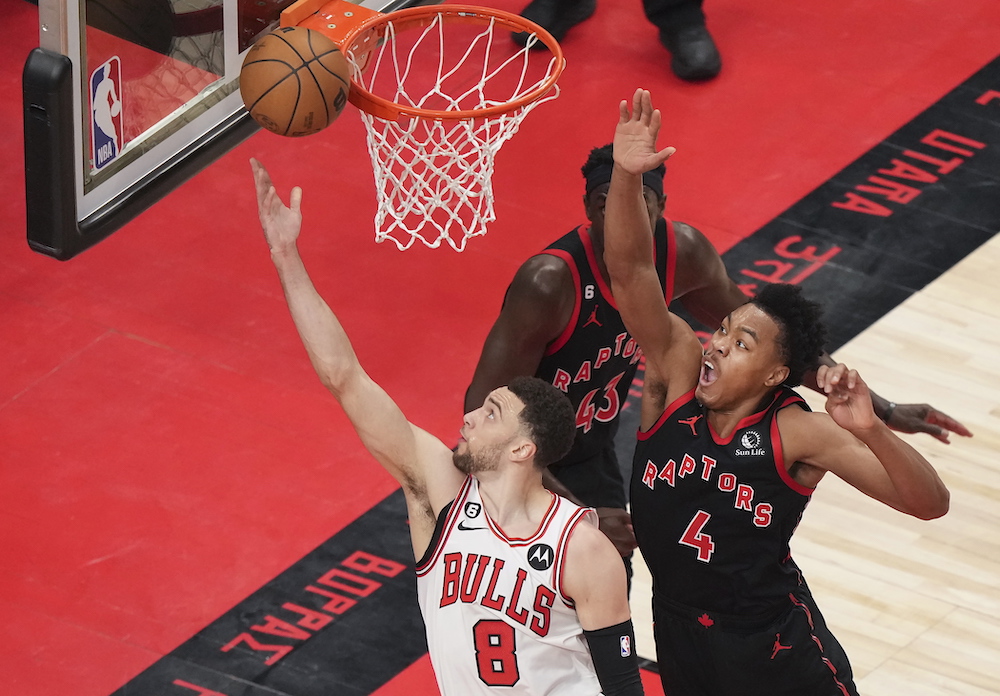 Chicago Bulls guard Zach LaVine scores past Toronto Raptors forward Scottie Barnes during the first half of an NBA basketball play-in tournament game Wednesday in Toronto. (The Canadian Press via AP)