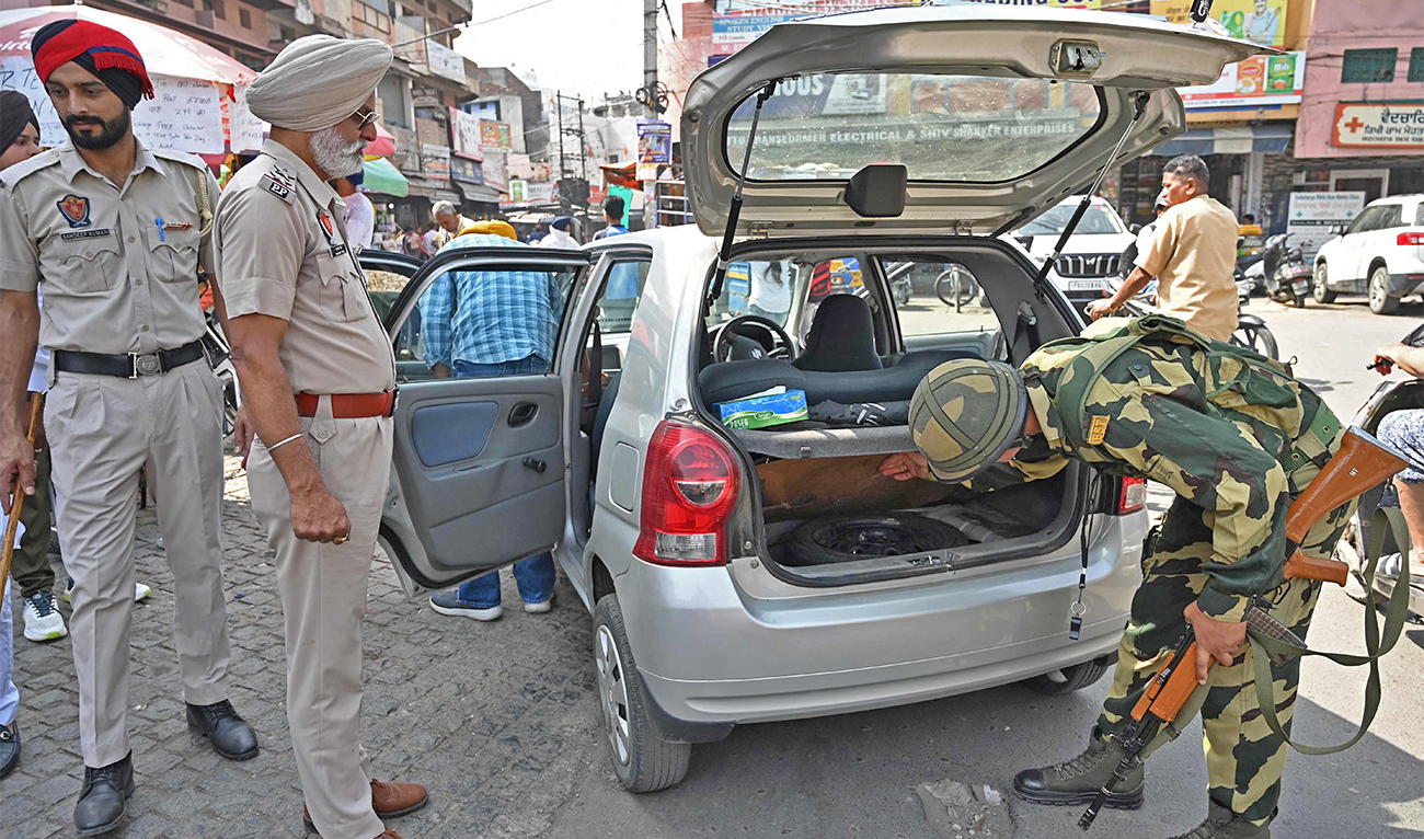 Border Security Force (BSF) personnel check a car along a street in Amritsar on April 13, 2023. (AFP/File)