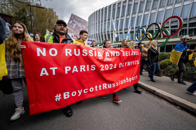 Ukrainians walk past the Olympic headquarters in Lausanne in March 2023 during a protest against the proposed IOC roadmap to organize the return to competition of Russian athletes under a neutral flag. (AFP/File)