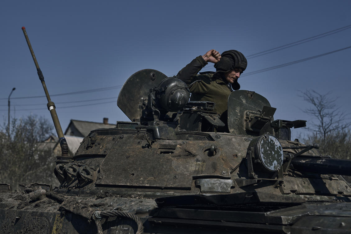 A Ukrainian soldier gestures atop a passing APC on the frontline in Bakhmut, Donetsk region, on Apr. 10, 2023. (AP)