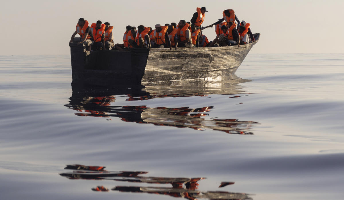 Migrants with life jackets provided by volunteers of the Ocean Viking, a migrant search and rescue ship run by NGOs SOS Mediterranee and the International Federation of Red Cross (IFCR), sail in a wooden boat as they are being rescued some 26 nautical miles south of the Italian Lampedusa island in the Mediterranean sea, on Aug. 27, 2022. (AP)