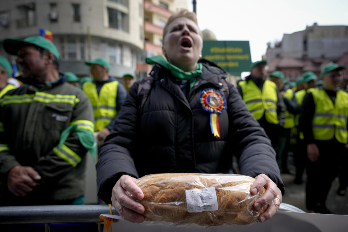 A woman holds a loaf of bread during a farmers' protest in front of the Representative Office of the European Commission in Bucharest on, April 7, 2023 (File/AP)