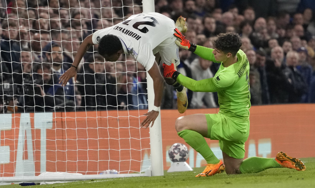 Real Madrid's Rodrygo, left, is fouled by Chelsea's goalkeeper Kepa Arrizabalaga after scoring his side's second goal at the Champions League quarterfinal second leg against Chelsea at Stamford Bridge stadium in London Tuesday. (AP)