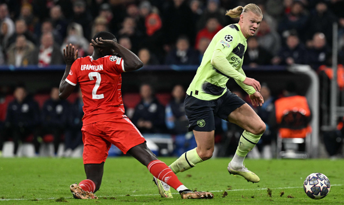 Manchester City's Norwegian striker Erling Haaland (R) runs past Bayern Munich's French defender Dayot Upamecano and towards the goal as he prepares to score their opening goal during the UEFA Champions League quarterfinal second leg against Bayern Munich. (AFP)