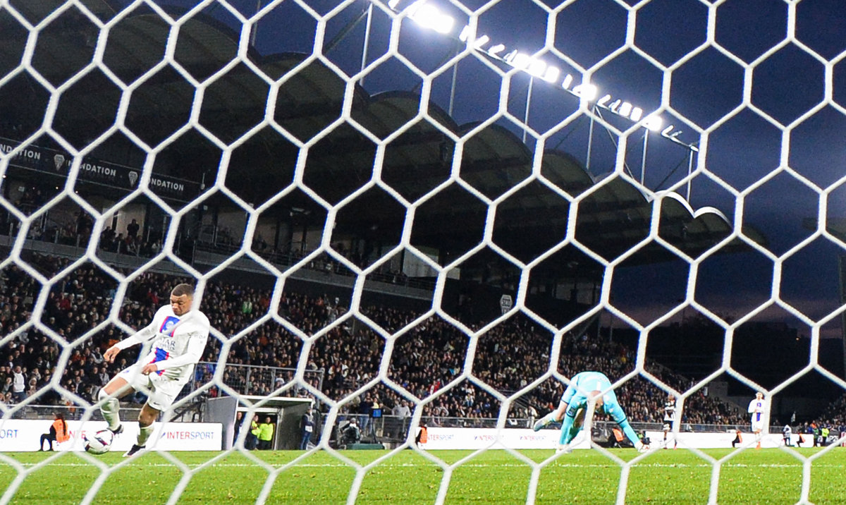 Paris Saint-Germain's French forward Kylian Mbappe (L) shoots and scores his team's second goal against Angers' French goalkeeper Paul Bernardoni during their French L1 football match at The Raymond-Kopa Stadium in Angers, western France on Friday. (AFP)