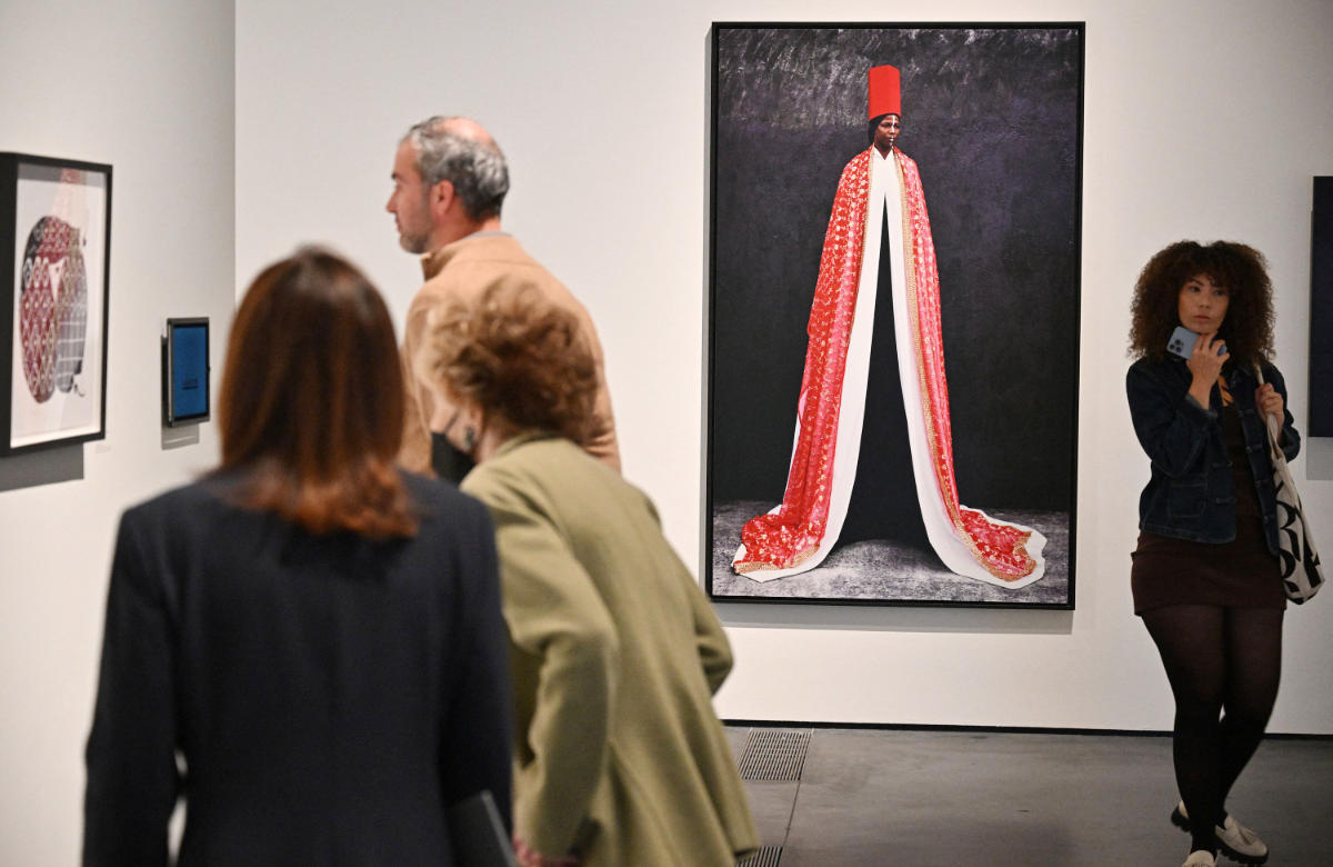 Visitors looks at works including ìRhokaya, 2010î a dye coupler print by Italian-born artist Maimouna Guerresi at the press preview for the exhibition ìWomen Defining Women in Contemporary Art of the Middle East and Beyondî at the Los Angeles County Museum of Art (LACMA) in Los Angeles, California, on April 19, 2023. (AFP)