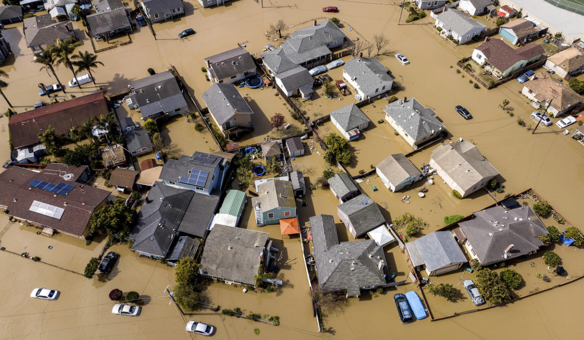 Floodwaters surround homes and vehicles in Monterey County, California.