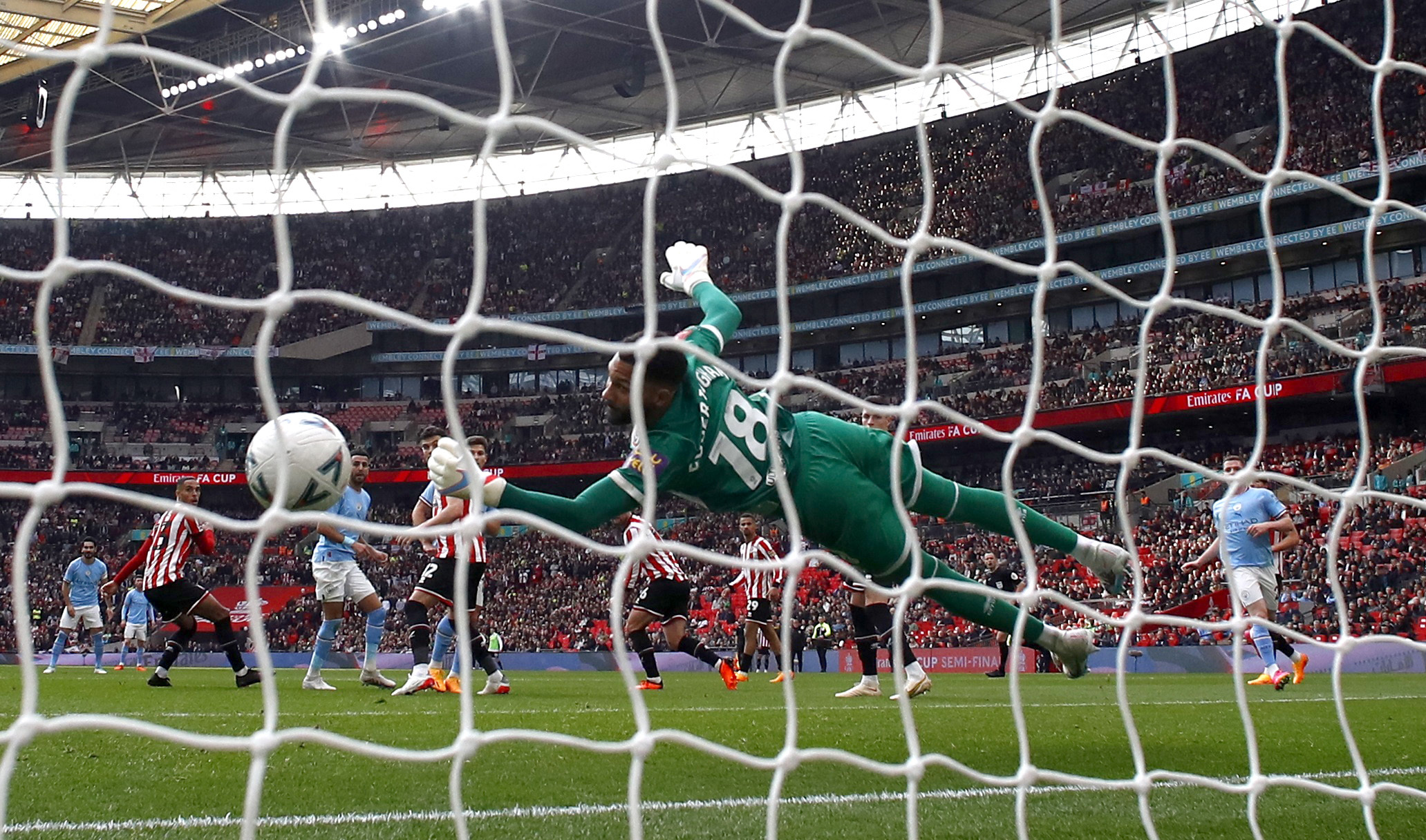 Manchester City's Riyad Mahrez scores their third goal past Sheffield United's Wes Foderingham to complete his hat trick during the FA Cup semifinal against Sheffield United. (Reuters)