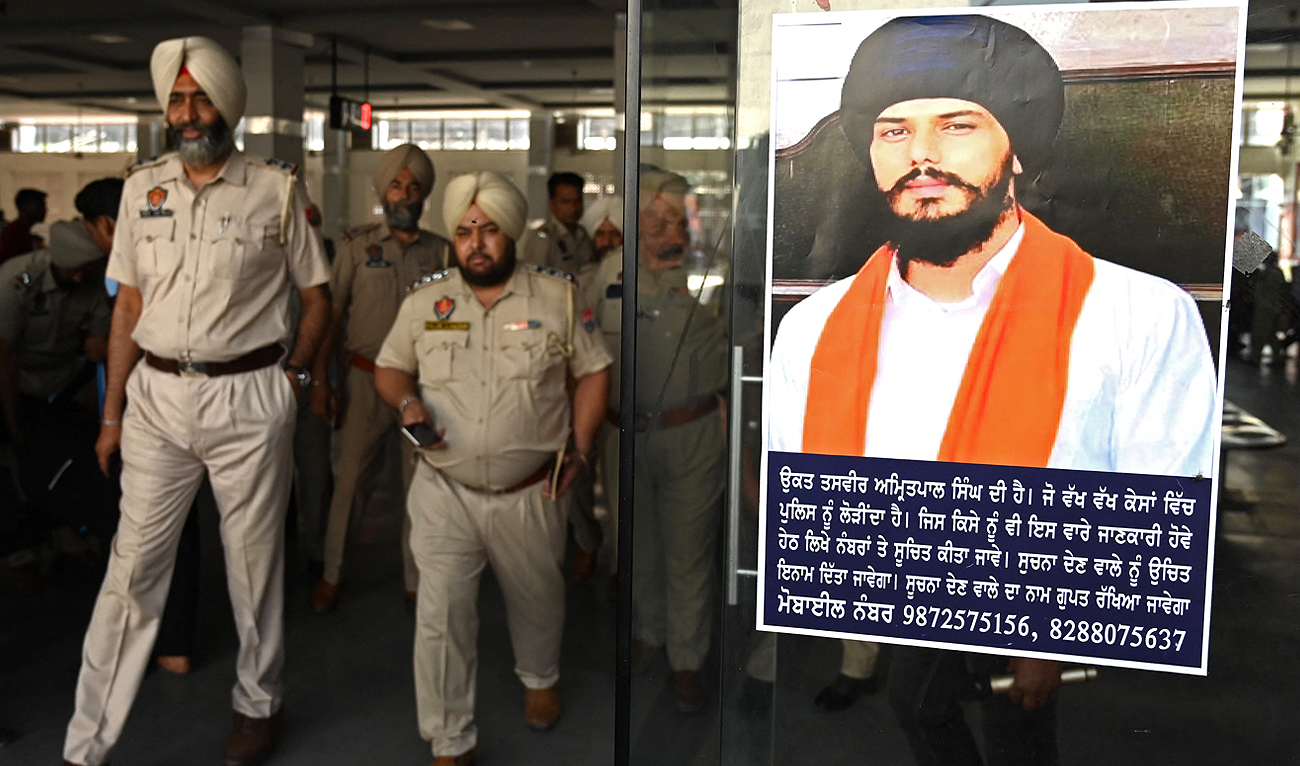 In this file photo taken on April 13, 2023, police stick Amritpal Singh's poster at a railway station in Amritsar. Firebrand fugitive Sikh separatist Amritpal Singh has been arrested after a massive manhunt that lasted more than a month, Indian police said on April 23. (Photo courtesy: AFP/File)