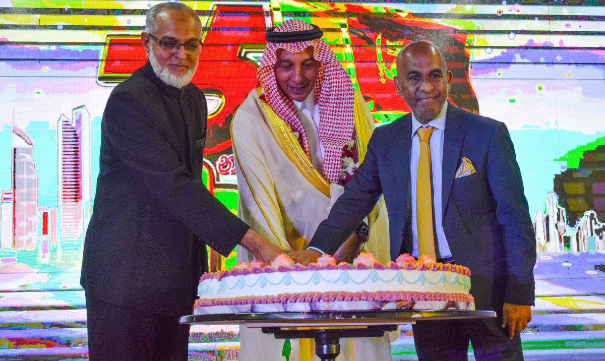 Sri Lanka's consul-general in Jeddah Falah Alhabshi Mowlana, left, cuts a cake alongside Mazen bin Hamad Al-Himali, director general at the Saudi Ministry of Foreign Affairs, right, during an event in Jeddah on Feb. 26. (Consulate General of Sri Lanka in Jeddah)