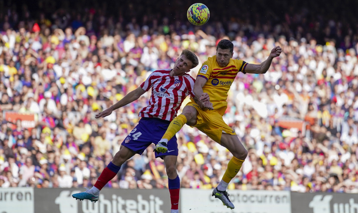 Barcelona's Robert Lewandowski, right, duels for the ball with Atletico Madrid's Pablo Barrios during a Spanish La Liga soccer match between Barcelona and Atletico Madrid, at the Camp Nou stadium in Barcelona, Spain, Sunday, April 23, 2023. (AP)